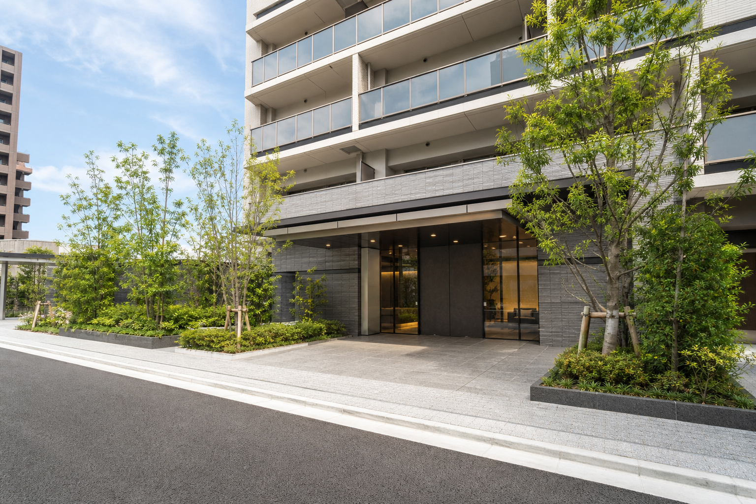 賃貸マンション外観：名古屋・愛知で賃貸契約の初期費用をクレジットカードや分割で支払える項目と、申込前に不動産会社へ確実に確認する質問と実務的なやり取り例を知りたいの判断先を象徴する現代的な賃貸マンション入口を道路側から広角で撮る。人物、看板、読める文字なし