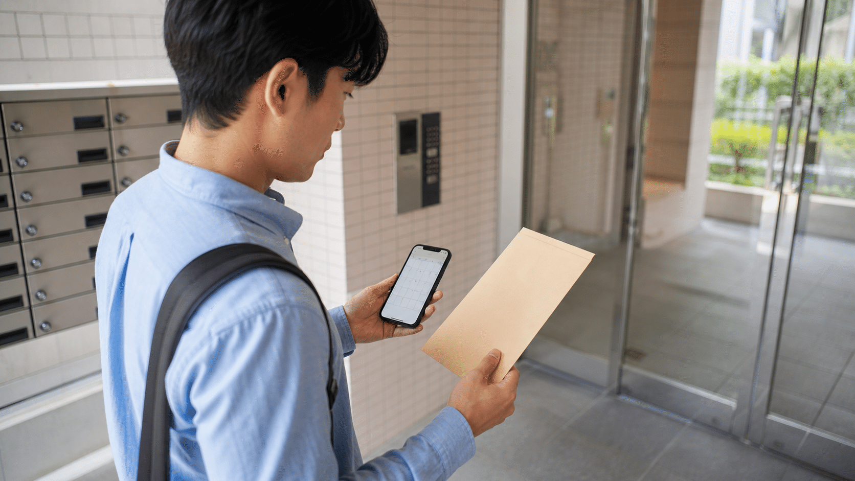 単身の入居予定者が保証料の通知とスマートフォンのカレンダーを照合する場面